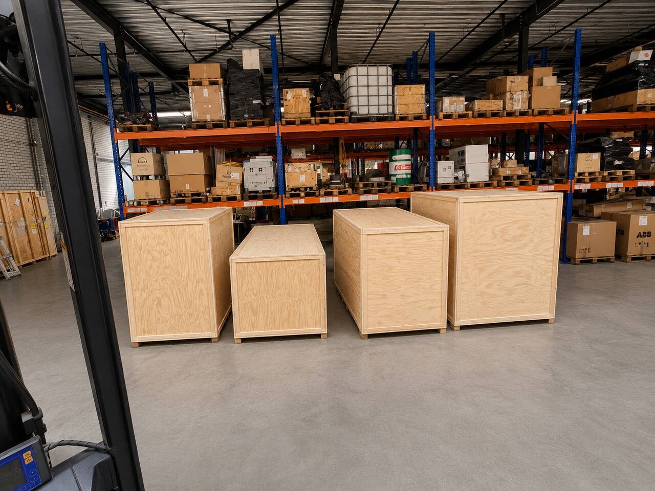 Houten exportkisten op maat in het magazijn van Cargo Donkey in Hoofddorp, met palletstellingen en logistieke opslag op de achtergrond.